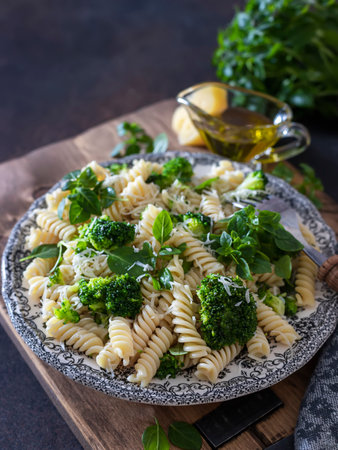 Fusilli with with broccoli, basil and parmesan cheese on a dark background. Proper nutrition. Sports nutrition. Dietary menu. Selective focusの写真素材