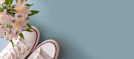 White sneakers on blue background. Women's shoes. Flat lay. Top viewの写真素材