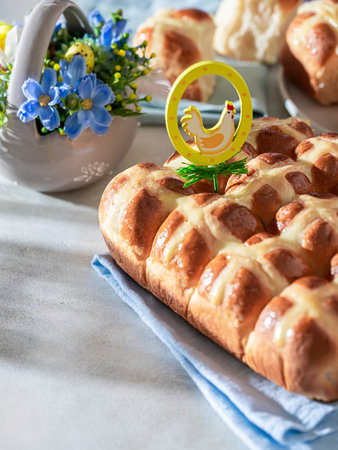 Homemade Hot Cross Buns on a light concrete background. Traditional Easter food. Easter holiday...