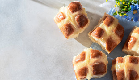 Homemade Hot Cross Buns on a light concrete background. Traditional Easter food. Easter holiday...