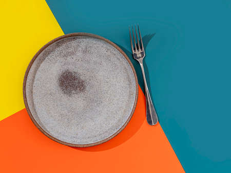 Empty plate and fork on a bright beautiful background. Concept for menu with cutlery. Copy spaceの写真素材