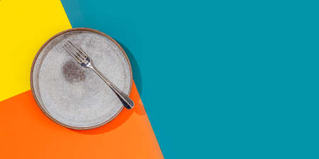 Empty plate and fork on a bright beautiful background. Concept for menu with cutlery. Copy spaceの写真素材