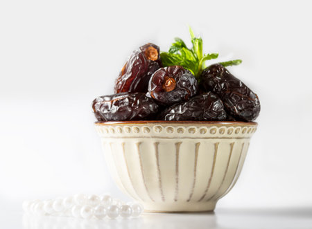 Dates fruit and rosary still life against on white background. Ramadan background greeting card....