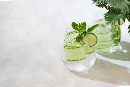 Detox cocktail cucumber and mint on a light background. Healthy nutrition diet concept. Homemade lemonade. Cold and refreshing detox water. Copy spaceの写真素材