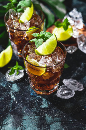 Cuba Libre with brown rum, cola, mint and lime. Cold Longdrink, alcohol cocktail. Place for text,...