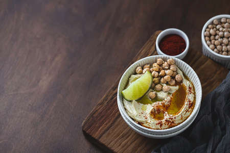 Chickpea hummus with olive oil and lime on a ceramic plate. Homemade classic hummus. Chickpea dishes, vegetarian dish. Selective focus, copy space.の写真素材