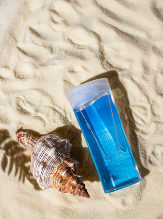 Summer skin care. Transparent cosmetic tube with sunscreen, gel on a sand background. Cosmetic...