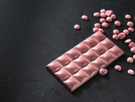 Pink chocolate on a black background. Ruby chocolate. The fourth type in chocolate. Selective focusの写真素材