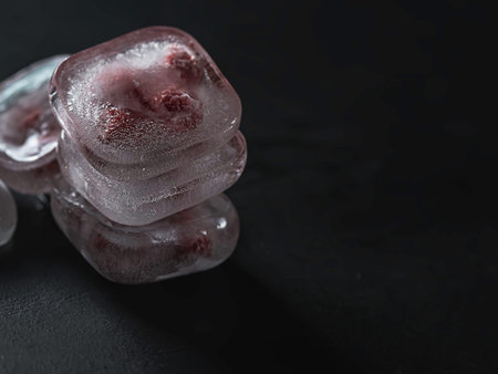 Raspberry frozen in the ice cube on black background. Fresh healthy summer eating.の写真素材