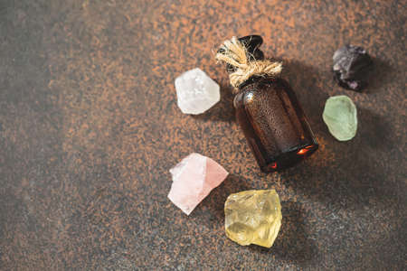 Glass bottle with oil, beautiful crystals and precious stones. Alternative medicine. Copy spaceの写真素材