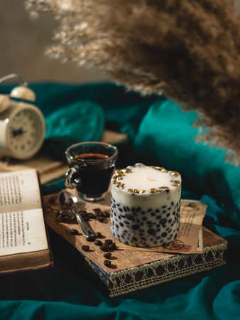 A wooden tray with a fragrant coffee candle and coffee on the bed. Hygge concept. Relaxation atmosphere. Luxurious lifestyle. selective focusの写真素材