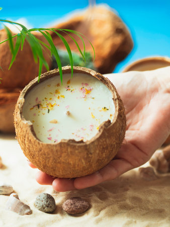 Original decorative handmade natural soy wax candle in a coconut. Candle in a coconut shell. Spa...