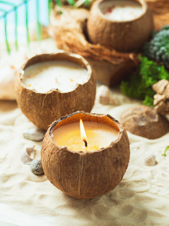 Original decorative handmade natural soy wax candle in a coconut. Candle in a coconut shell. Spa aroma candles. close up.の写真素材