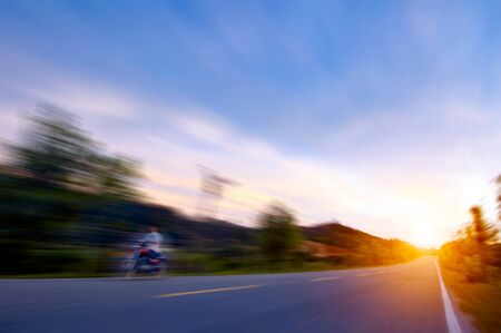 Sunrise, the endless road, and occasionally see a car roaring past.の写真素材