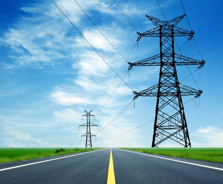 High-voltage tower across the highwayの写真素材