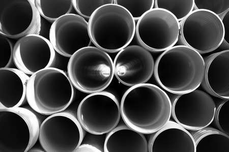 gray PVC tubes plastic pipes stacked in rows patternの写真素材