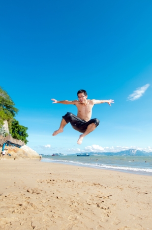Man jumping on a tropical beachの写真素材