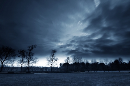 Road in field and stormy cloudsの写真素材