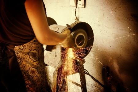 Worker cutting metal with grinder. Sparks while grinding ironの写真素材