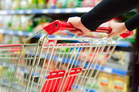 Lady pushing a shopping cart in the supermarket.の写真素材