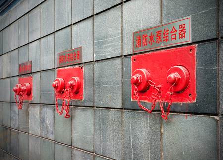 Fire pump adapter on the building wallの写真素材