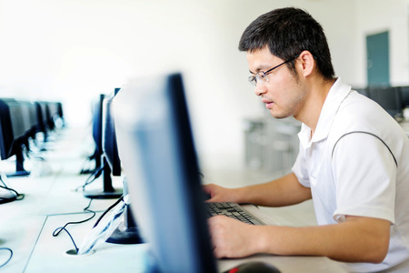 Asian man in front of the computer workの写真素材
