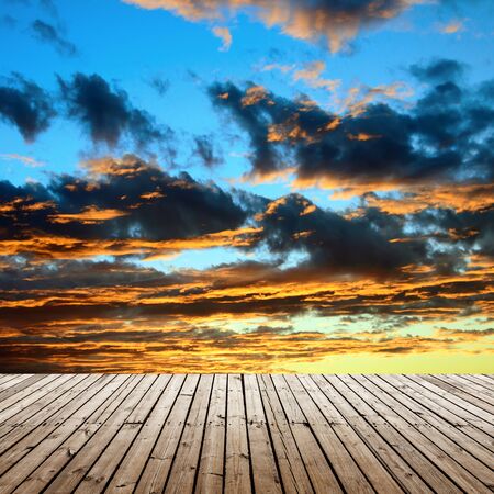 landscape golden sunset and sun beams through the cloud, view from wooden platformの写真素材