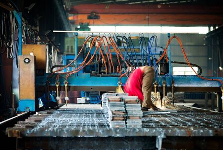 Steel factory production line, flame cutting machines and workers at work.のeditorial素材