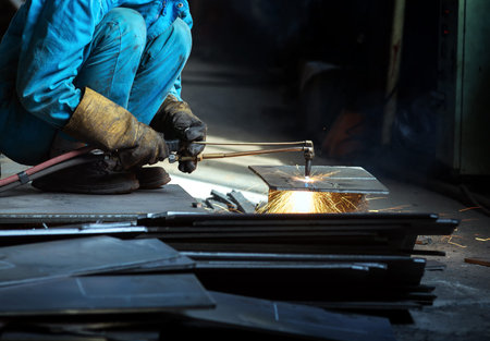 Workers at the construction site using a metal cutting torch