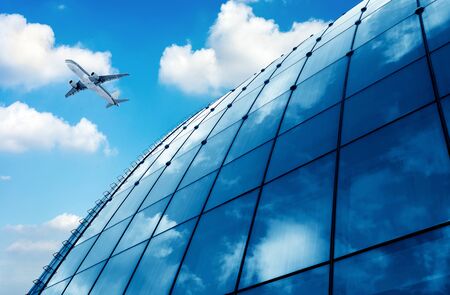 glass curtain wall and aircraft against a blue skyのeditorial素材