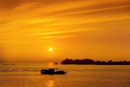 Silhouette of fishing boat at sea during sunsetの写真素材