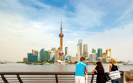 SHANGHAI-MAY 14, 2012. Tourists on Bund boulevard with Pudong district on background. Pudong...