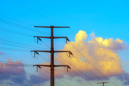 High voltage poles, located in the evening sky.