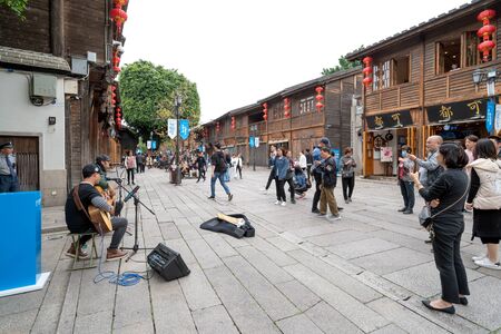 Sanfang Qixiang (Three Lanes and Seven Alleys), Fuzhou, China - 07 May 2019: A famous tourist destination, tourists watched by street singers.のeditorial素材