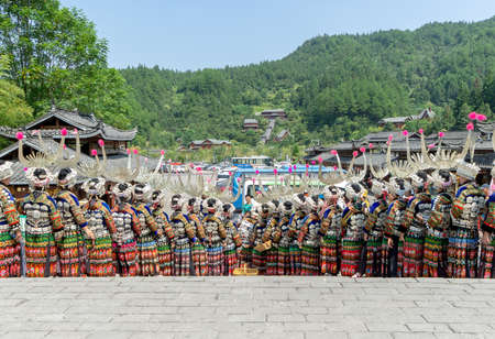 Xijiang, China-SEPTEMBER 2,2020: Miao women dancing in full traditional festival regalia and colorful costume with silver horn headdress in Xijiang ethnic minority Miao village, Guizhou, Chinaのeditorial素材