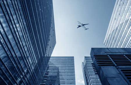 Modern urban picture, airplane on the sky.の写真素材