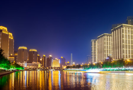 Illuminated city waterfront downtown skyline with Haihe river,Tianjin,China.の写真素材