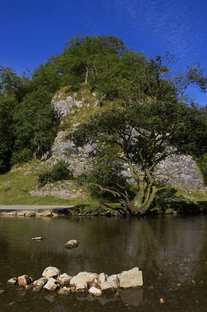 View of a rocky hill with river in foregroundの写真素材