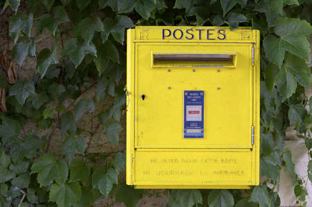Yellow French post box on wall, chateau de chenonceauの写真素材