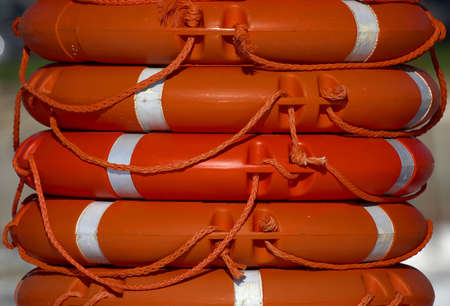Orange life rings stacked in a neat pile, port cala bona, mallorca, majorca, spainの写真素材