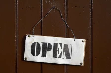 Open sign pinned onto a painted wooden doorの写真素材