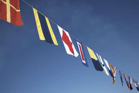 nautical flags strung along the line of a cruise shipの写真素材