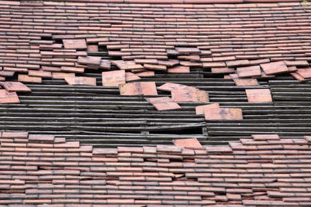 roof of an old derelict house with a large hole exposing the timber rafters which would support the tiles bedworth coventry ukの写真素材