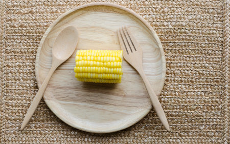 Boiled corn on Wooden Plate and Wooden Spoon