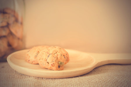 Oat cookies with pumpkin seeds and raisin on a wooden plate (Filtered image processed vintage...