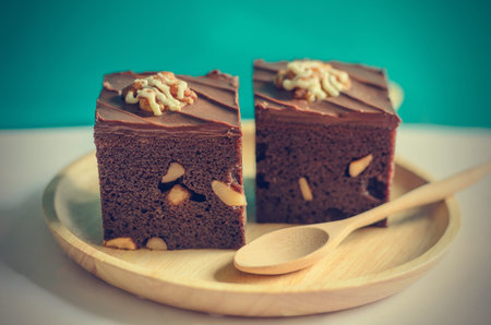Brownies on wooden plate with green blackground (vintage effect)の写真素材