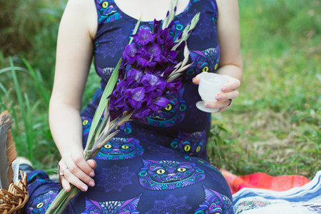 Close up blue gladiolus concept photo. Flower bouquet. Front view photography with woman in blue dress on background. High quality picture for wallpaper, travel blog, magazine, articleの写真素材