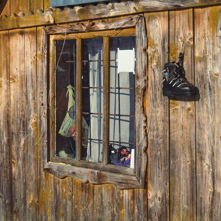 Close up wooden cabin window concept photo. Traditional home in the forest. Front view photography with exterior on background. High quality picture for wallpaper, travel blog, magazine, articleの写真素材