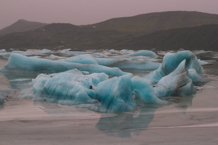 Irregular ice pieces in valley landscape photo. Beautiful nature scenery photography with mountain...