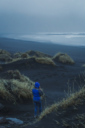 Woman on Reynisfjara beach landscape photo. Beautiful nature scenery photography with sea on background. Idyllic scene. High quality picture for wallpaper, travel blog, magazine, articleの写真素材